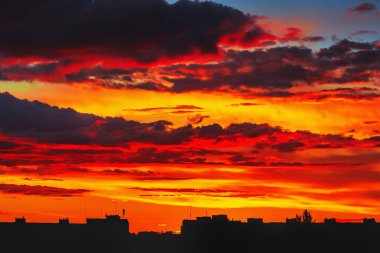 Gün batımında gökyüzü ve bulutlar akşam şehrin siluet binaları üzerinde.