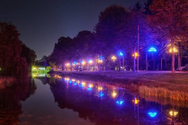 Lutsk (Ukrayna) parkında bulunan şemsiye biçimindeki fener sokakları geceleri kanalın suyuna yansımaktadır..