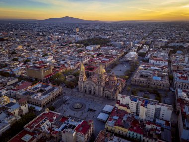 Metropolitan Katedrali, plazalar, sömürge mimarisi ve gökyüzünde kopya alanı olan geniş şehir siluetinin yer aldığı Guadalajara, Jalisco şehir merkezinin gündoğumu manzarası.