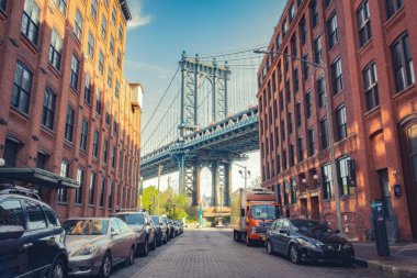 Manhattan Köprüsü 'nün ikonik manzarası DUMBO, Brooklyn, New York' taki tarihi kırmızı tuğla binalar tarafından çerçevelenmiştir..