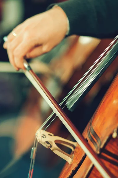 Orquesta sinfónica en el escenario, manos tocando el violonchelo — Foto de Stock