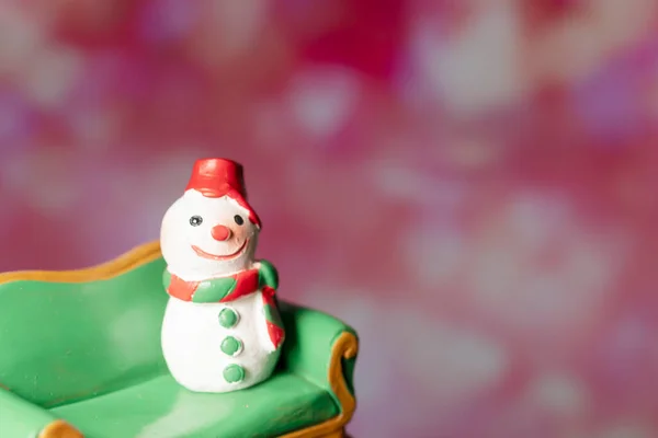 Model Met Een Sneeuwpop Zittend Een Groene Bank Tegen Een — Stockfoto