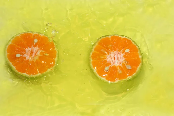 Orangen Auf Gelbem Hintergrund Zusammen Mit Wassertropfen Schneiden — Stockfoto