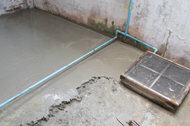 Pürüzsüz olması için yere çimento dökülüyor.