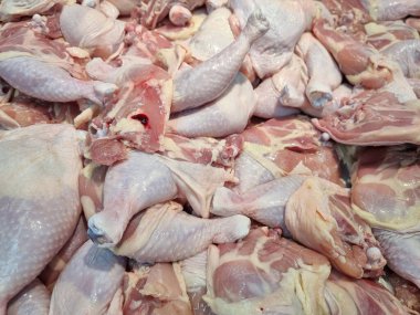 Arka planda taze çiğ tavuk parçaları var.