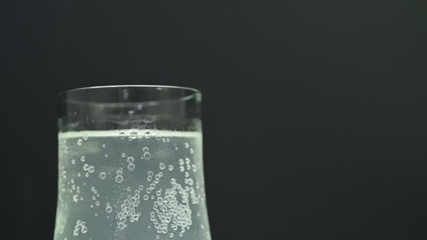 Water Spatten Terwijl Gieten Helder Glas Close Zwarte Achtergrond — Stockvideo