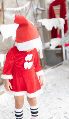 Noel tatillerinde Çocuklar Günü Kırmızı Elbisesi ve çocuklukta kırmızı elbiseli gülümseyen kız kavramları.