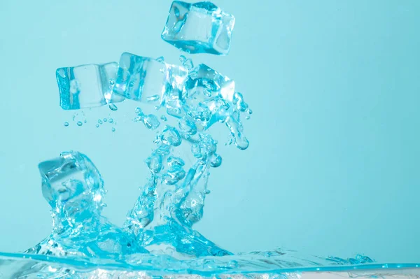 蓝色背景上喷水冰块的概念 — 图库照片