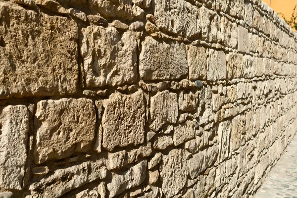 太陽の光で外ベージュの天然石の壁のクローズアップ — ストック写真