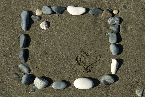 Kare Çerçeve Taşlardan Kumsaldaki Kumsala Çizilmiş Kalple — Stok fotoğraf