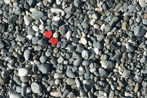 Δύο Κόκκινες Φιγούρες Σχήμα Καρδιάς Ανάμεσα Πέτρες Στην Παραλία — Φωτογραφία Αρχείου