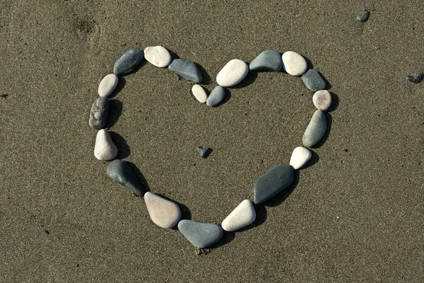 Herzförmige Figur Aus Strandsteinen Sand Sonnenlicht lizenzfreie Stockfotos