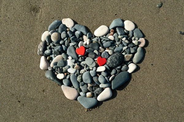 Hjärtformad Figur Från Strandstenar Och Två Små Röda Hjärtan Sanden Stockbild