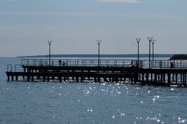 Işıldayan deniz suyu ve iskele sokak lambaları ve bisikletle