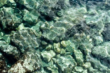 Parlak şeffaf deniz suyu ve su altı taşlarının dokusu 