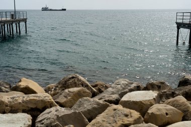 Beyaz kayalar, rıhtımlar ve ufukta gemi manzarası