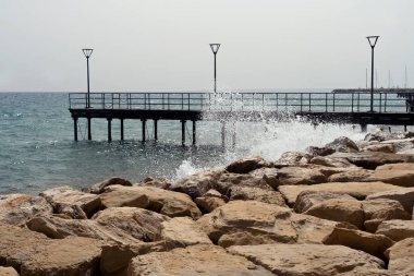Kıbrıs Rum Kesimi 'nin Limasol kentindeki Molos rıhtımında taş seti ve deniz rıhtımı dalgalı ve tozlu gökyüzü 