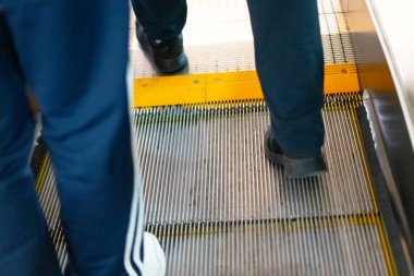 İnsanlar yürüyen merdiven boyunca yürür.