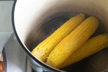 Ateşin üstünde haşlanmış mısır var.