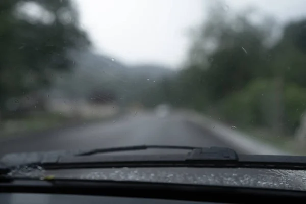 Old car driving in the rain