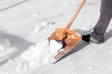 Kar küreğiyle kar temizleme.