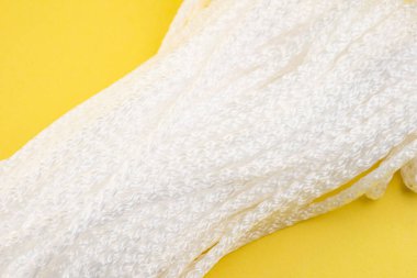 Sarı arka planda giysileri kurutmak için halat.