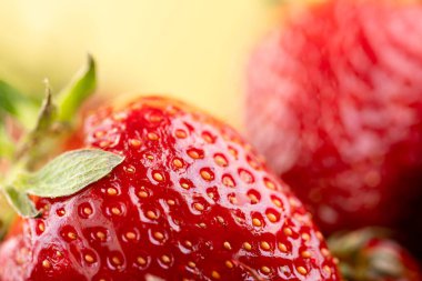 Sarı arka planda olgun çilekler.