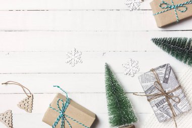 Noel ya da kış kompozisyonu. Noel hediyeleri, köknar ağacı, örgü battaniye ve beyaz ahşap arka planda süsler. Düz konum, üst görünüm, kopyalama alanı.