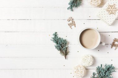 Noel kompozisyonu. Bir fincan kahve, yemyeşil ağaç, beyaz ahşap arka planda hediyeler ve süsler. Kış, tatil konsepti. Düz konum, üst görünüm, kopyalama alanı.