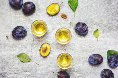 Rakija, rakı veya rakı, mayalanmış meyvelere dayanan Balkan güçlü bir alkollü içki türü. Gri sone masasında erik rakısı, üst manzara..