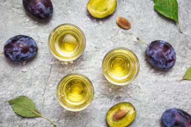 Rakija, rakı veya rakı, mayalanmış meyvelere dayanan Balkan güçlü bir alkollü içki türü. Gri sone masasında erik rakısı, üst manzara..