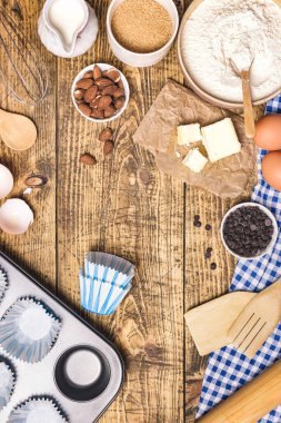 Hamur işi pişirme ve pişirme çerçevesi ya da malzemeli kek ve çatal bıçak. Un, şeker, süt, yumurta, tereyağı ve badem kırsal ahşap zemin üzerinde metin için kopyalama alanı, düz uzanma.