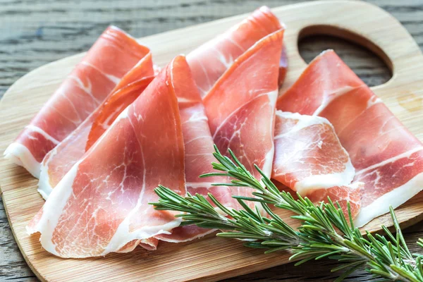 Fatias de jamon na tábua de madeira — Fotografia de Stock