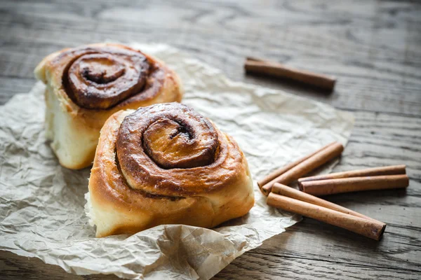 Cinnamon rolls on the wooden background — Stock Photo, Image