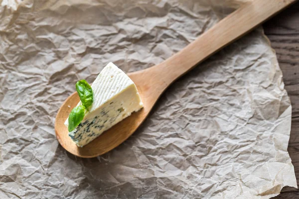 Stuk van de blauwe kaas op de houten lepel — Stockfoto