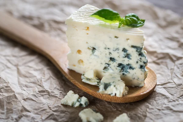 Stuk van de blauwe kaas op de houten lepel — Stockfoto