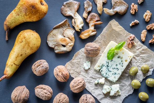 Blue cheese with walnuts, oyster mushrooms and green olives — Stock Photo, Image