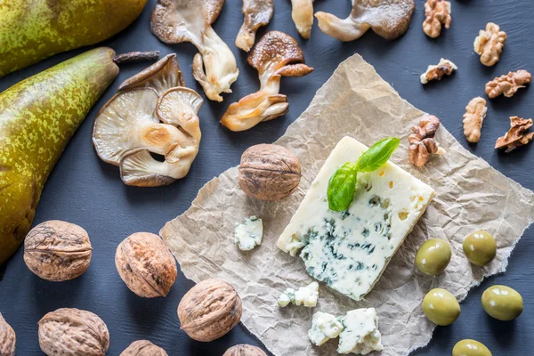 Blue cheese with walnuts, oyster mushrooms and green olives — Stock Photo, Image