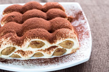 Tiramisu kahverengi zemin üzerine plaka üzerinde