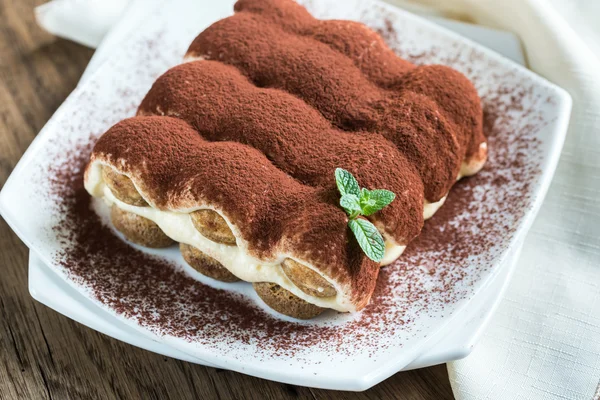 Tiramisù sul piatto sullo sfondo di legno — Foto Stock