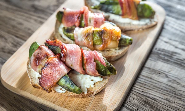 Pane tostato con crema di formaggio e avocado avvolto nella pancetta — Foto Stock