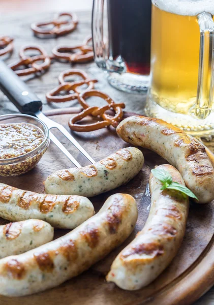 Gegrilde worstjes met pretzels en bier mokken — Stockfoto