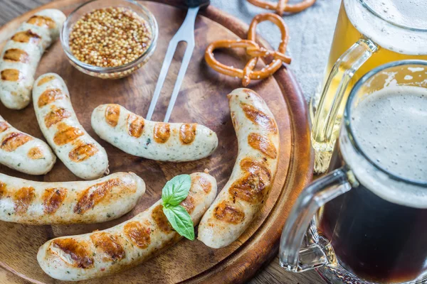 Salsichas grelhadas com pretzels e canecas de cerveja — Fotografia de Stock