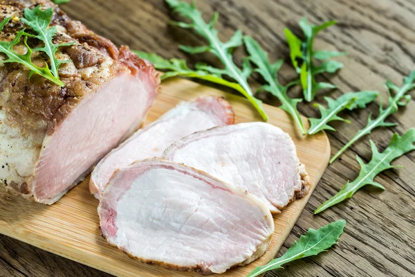 Pečené maso s čerstvou rukolou na dřevěné desce — Stock fotografie