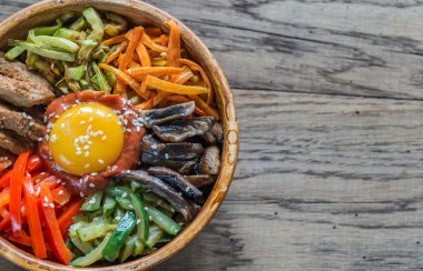 Ahşap masa üzerinde bibimbap kase