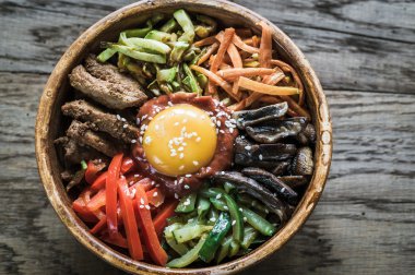 Ahşap masa üzerinde bibimbap kase