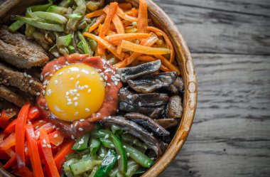 Ahşap masa üzerinde bibimbap kase
