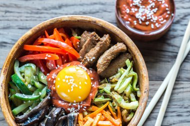 Ahşap masa üzerinde bibimbap kase