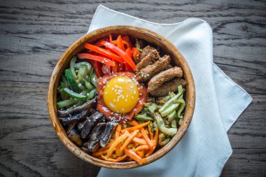 Ahşap masa üzerinde bibimbap kase