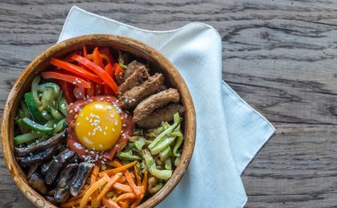 Ahşap masa üzerinde bibimbap kase